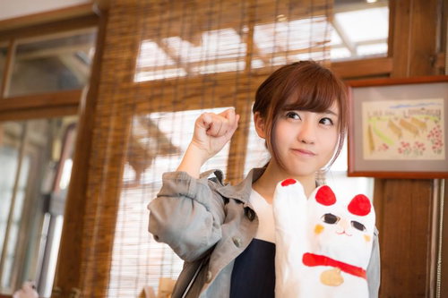 大原中央商店街の招き猫のマネをする観光客の女性