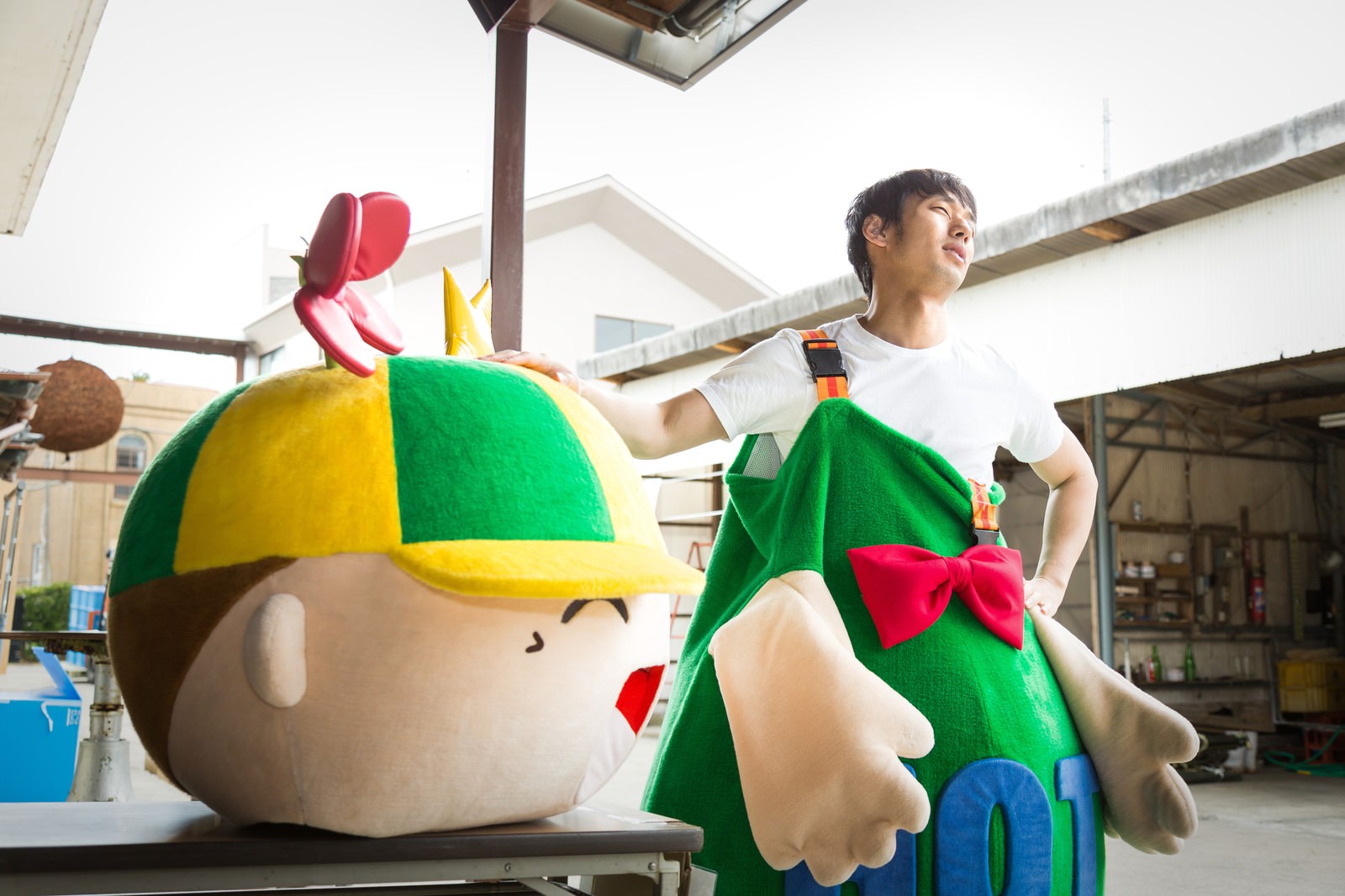 大原中央商店街のマスコットと中の人が屋外で休憩［モデル：ホットくん 大川竜弥］