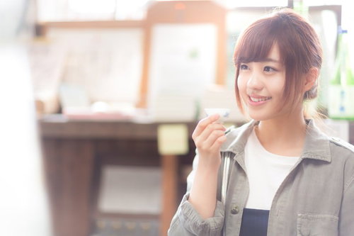 木戸泉の純米酒を味わい笑顔がこぼれる女性