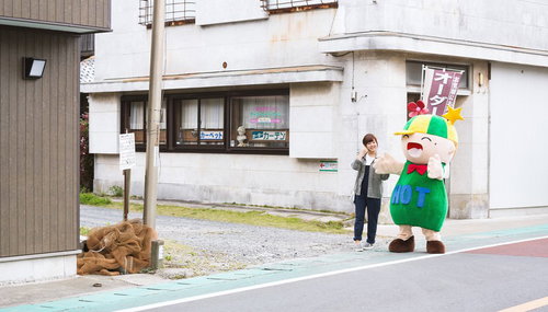 大原中央商店街で両手を広げて道幅を表現するHOTくん