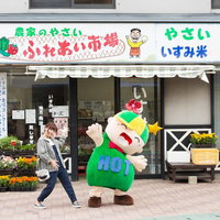 農家のやさい！ふれあい市場をアピールする女性とゆるキャラの写真