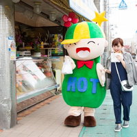 大原中央商店街でコロッケを食べ歩くゆるキャラと女性の写真