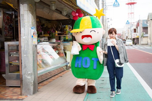 大原中央商店街でコロッケを食べ歩くゆるキャラと女性