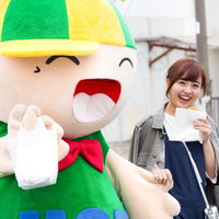 大原中央商店街のゆるキャラと笑顔でコロッケをほおばる女性の写真