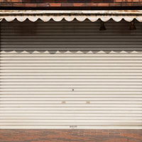 本日は定休日、白いトタンシャッターが閉じた商店街の写真