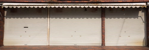 本日は定休日、白いトタンシャッターが閉じた商店街