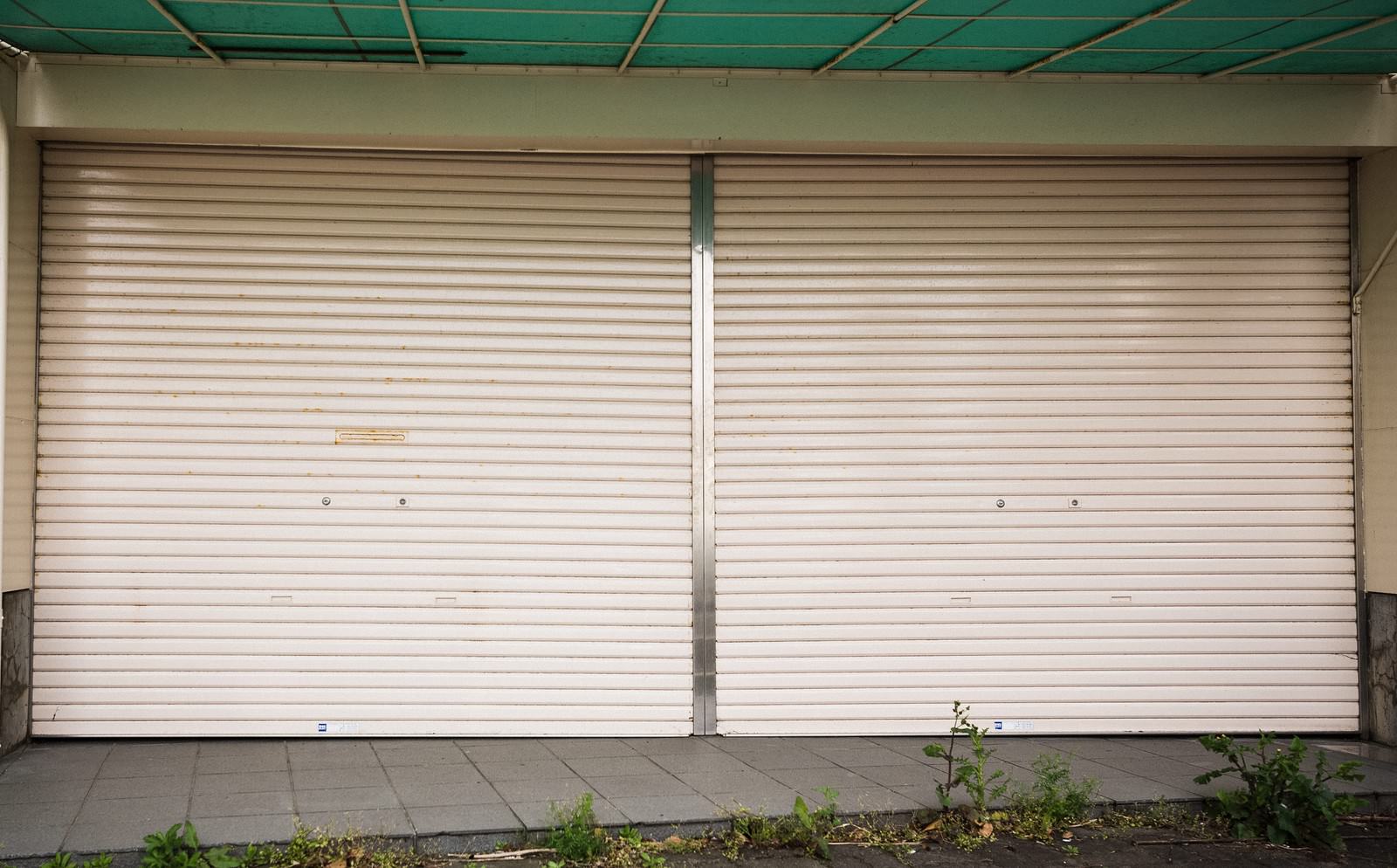 商店街に並ぶ閉じたベージュのシャッター