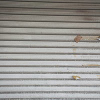 張り紙の跡が残る金属製シャッター 大原中央商店街の空き店舗の写真