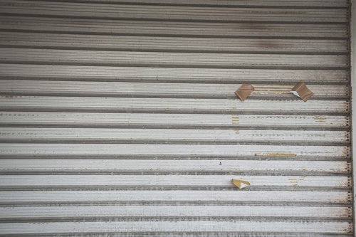 張り紙の跡が残る金属製シャッター 大原中央商店街の空き店舗