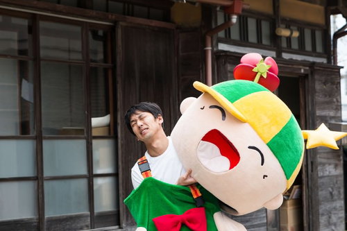 アクセサリーの向きを修正するため頭部を外すゆるキャラと中の人