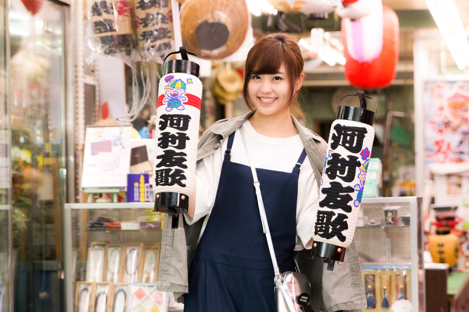 提灯を両手に持ち笑顔を見せる大原中央商店街の女性［モデル：河村友歌］