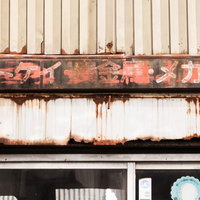 トケイ・貴金属・メガネの錆びた看板と廃墟化した商店街の写真