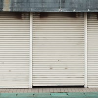 閉じた商店のシャッター4枚並ぶ大原中央商店街の風景の写真