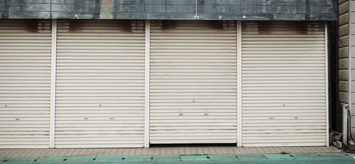 閉じた商店のシャッター4枚並ぶ大原中央商店街の風景