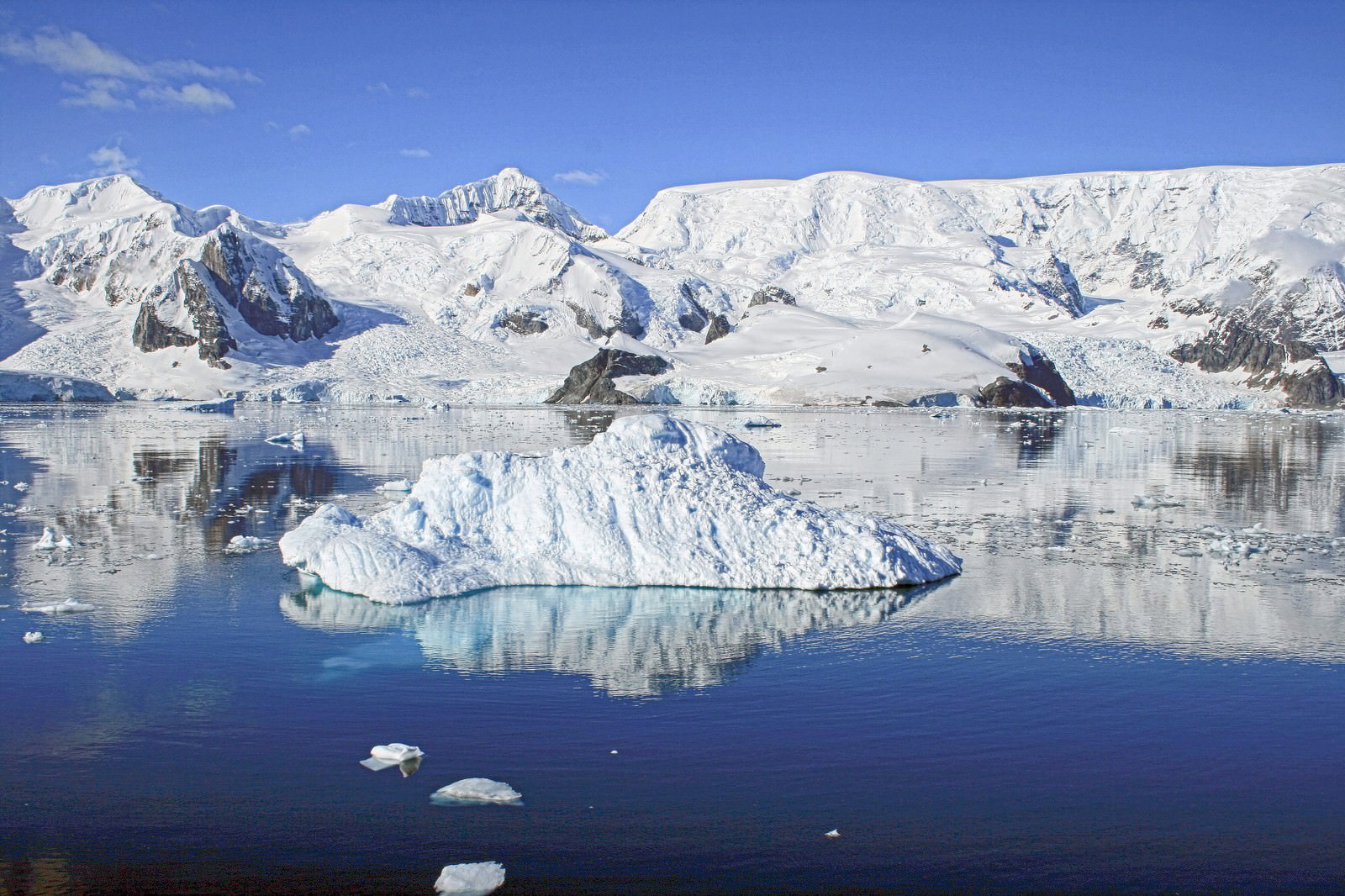 南極パラダイスベイに浮かぶ白い流氷と奥に連なる雪山、青い海面