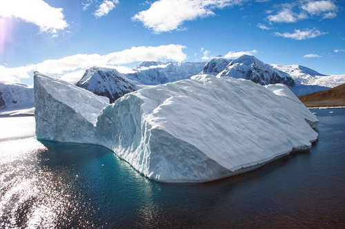 南極の流氷が浮かぶ水上の氷の島、雪山を背景にした風景