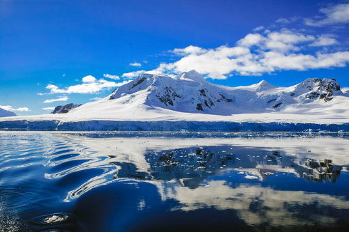 青く澄んだ空と南極大陸の雪峰、氷河と海氷の絶景