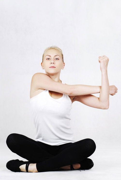 あぐらの状態から背筋を伸ばすヨガ中の女性