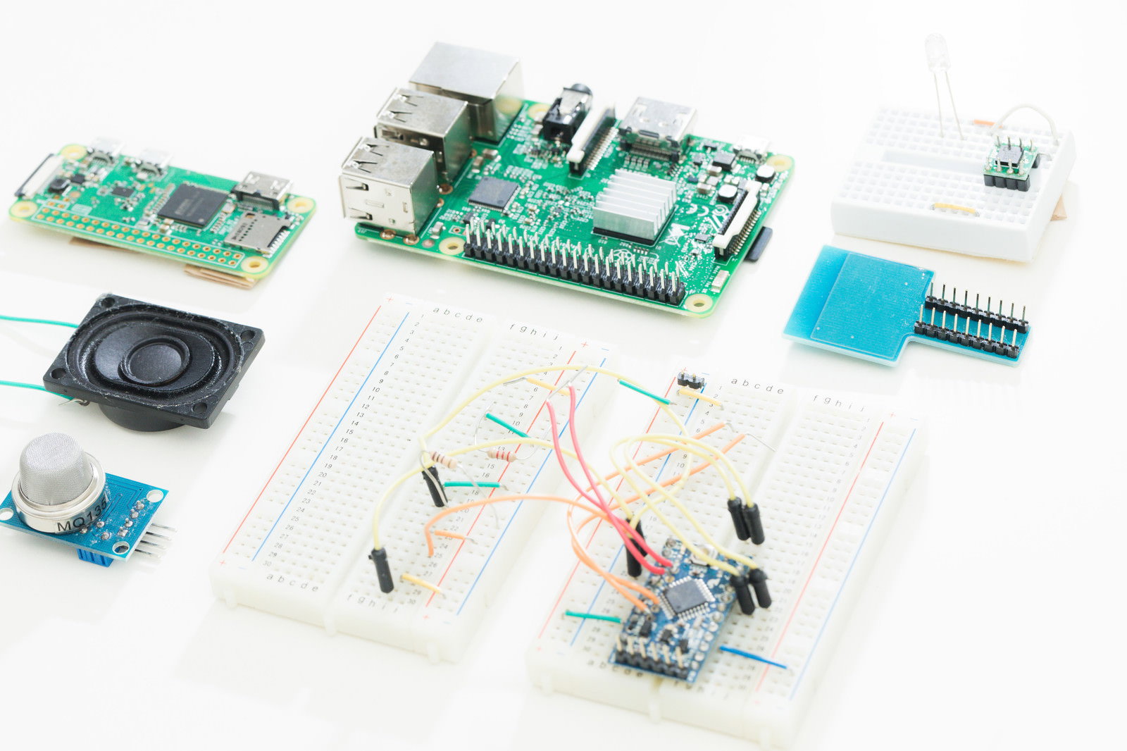 白い背景に配置されたRaspberry Piとブレッドボード、電子部品のセット