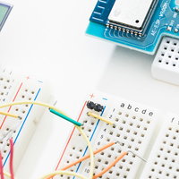 白いブレッドボードとカラフルな配線による電子回路のセットアップの写真