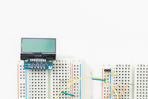 白い背景に配置した小さなモノクロ液晶とブレッドボード