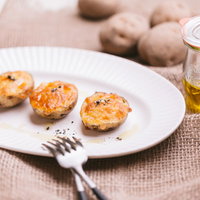 焼きたてのじゃがいもチーズグラタン、黒胡椒をかけたおいしい一皿の写真