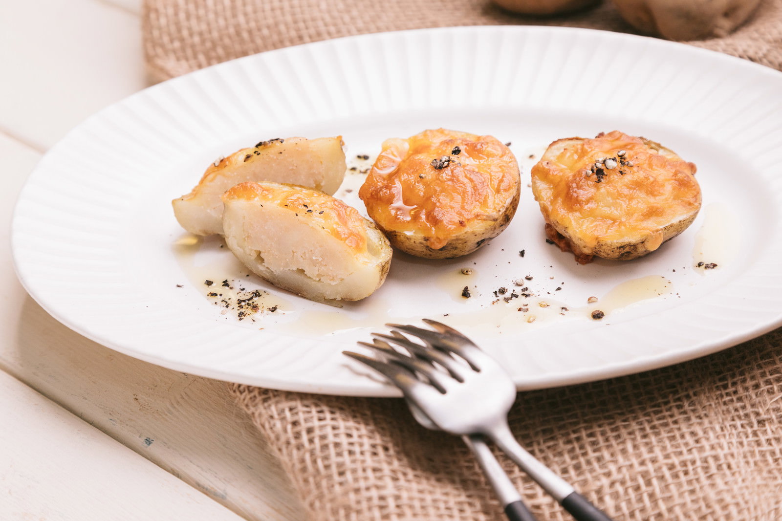 白い皿に並んだチーズ焼きじゃがいもグラタン