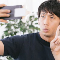 星型の自撮りライトを使っても表情が暗い男性のセルフィーの写真