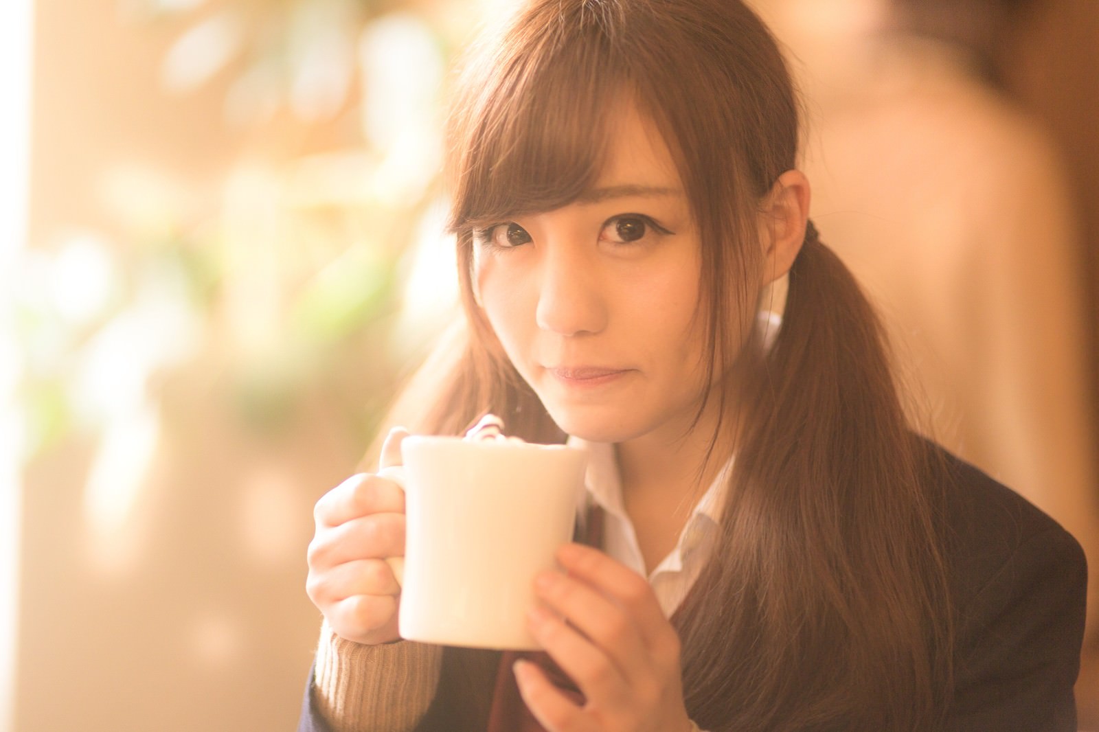 カフェでマグカップを持つ制服姿の女子高生［モデル：河村友歌］