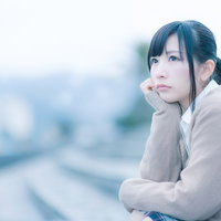 もの寂しげな表情で考えこむ女子高生、屋外で座り込むの写真