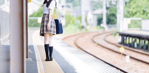 誰もいない田舎の駅のホームで振り返る女子高生