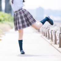 チェック柄スカートで踊るように浮かれる女子高生の写真