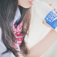 熱中症対策としてポカリスエットで水分補給する女子高生の写真