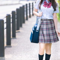 通学中の女子高校生が青いバッグを持って歩くの写真