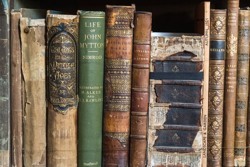 背表紙がボロボロに擦り切れた古い洋書の積み重ね