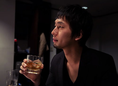 隠れ家的なバーでウイスキーを嗜むIT長者風の余裕ある男性