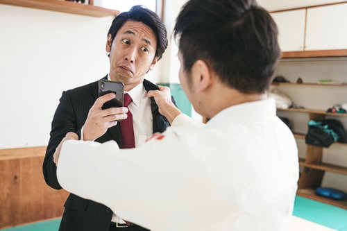 柔道の組み手中もスマホを手放さない男性 - ビジネス