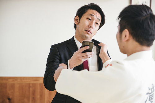 「いま撮った動画見たい？」と煽るスーツ男性