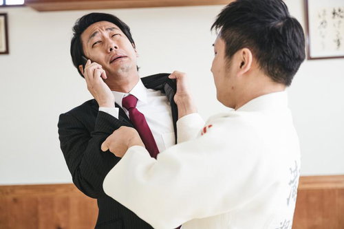 スーツのサラリーマンをぶん投げる柔道着の男性