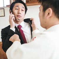 悪態をつくスーツ姿のサラリーマンに電話を切られる瞬間の写真