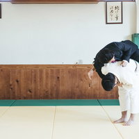 スーツ姿で一本背負いに投げられるサラリーマンの写真