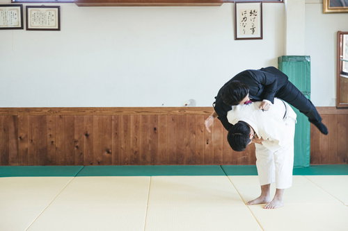スーツ姿で一本背負いに投げられるサラリーマン