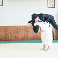 スーツ姿で豪快に投げられる会社員の一本背負いの写真