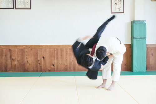 スーツ姿で一本背負いを決めるサラリーマン