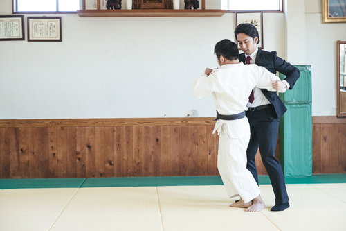 柔道場でサラリーマンを投げる柔道の投げ技