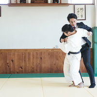 柔道場でサラリーマンを投げる瞬間の組み手と投げ技の写真