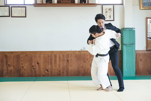 柔道場でサラリーマンを投げる瞬間の組み手と投げ技