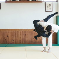 柔道場でサラリーマンを投げる男性の投げ技の写真