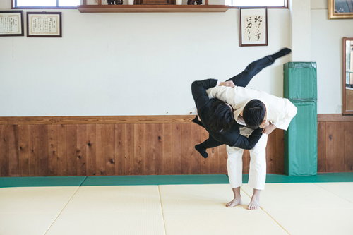 柔道場でサラリーマンを投げる男性の投げ技