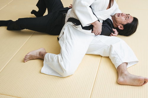 暴れた輩をスーツ姿で袈裟固めで無力化する柔道男性